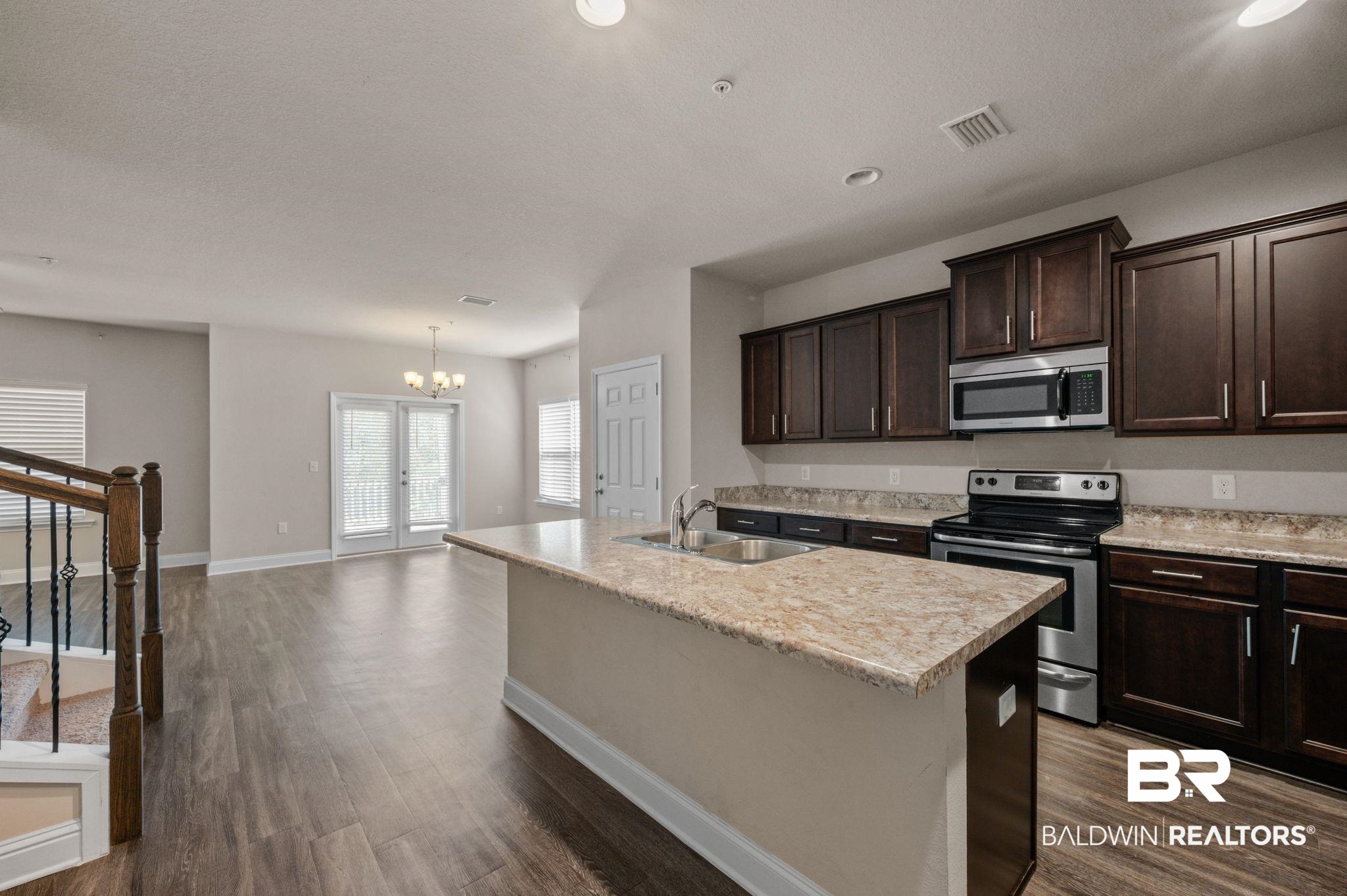 6903 Spaniel Drive, Unit B Spanish Fort, AL 36527 - Photo 5 of 28 Kitchen with a kitchen island with sink, a sink, visible vents, light countertops, and appliances with stainless steel finishes