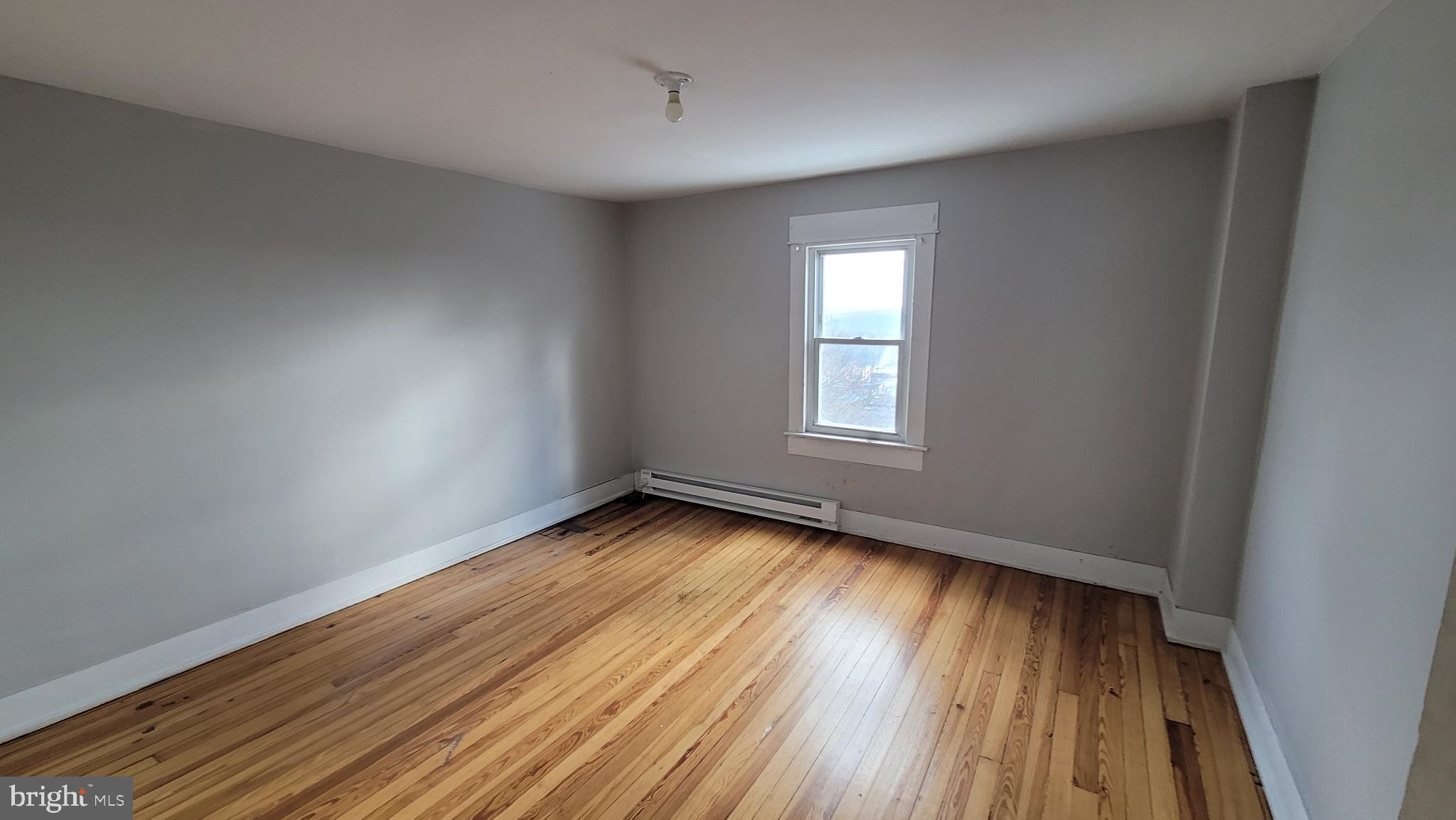 262 Indiana Avenue Shenandoah, PA 17976 - Photo 27 of 35 wooden floor in an empty room with a window