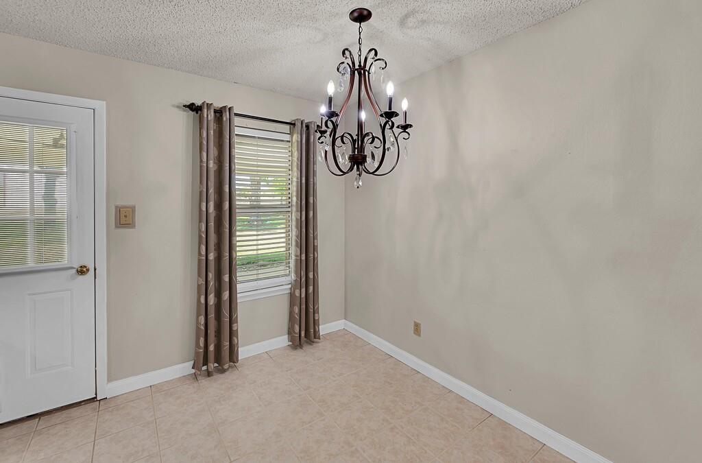 2857 Country Spring Road Lorena, TX 76655 - Photo 13 of 40 Unfurnished dining area with a textured ceiling and a chandelier