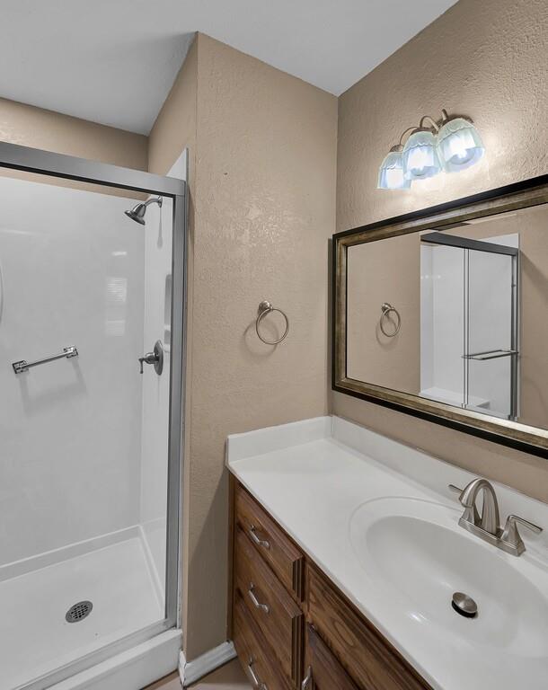 2857 Country Spring Road Lorena, TX 76655 - Photo 16 of 40 Full bath with a textured wall, vanity, and a stall shower