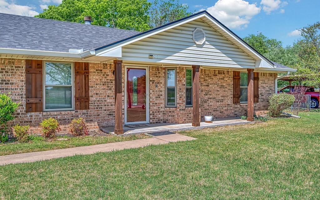 2857 Country Spring Road Lorena, TX 76655 - Photo 2 of 40 View of front of property with covered porch, brick siding, a front lawn, and a shingled roof