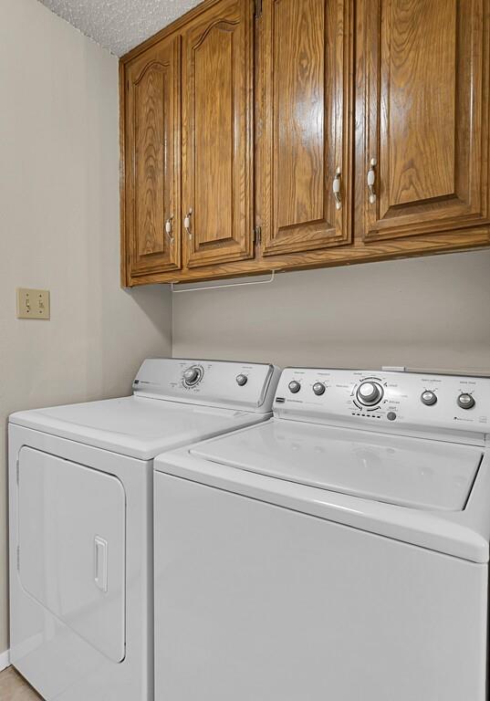 2857 Country Spring Road Lorena, TX 76655 - Photo 21 of 40 Laundry area featuring cabinet space, separate washer and dryer, and a textured ceiling