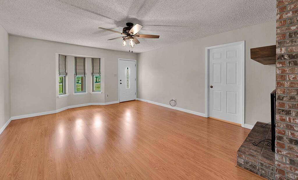 2857 Country Spring Road Lorena, TX 76655 - Photo 6 of 40 Unfurnished living room with light wood-type flooring, a textured ceiling, and a ceiling fan