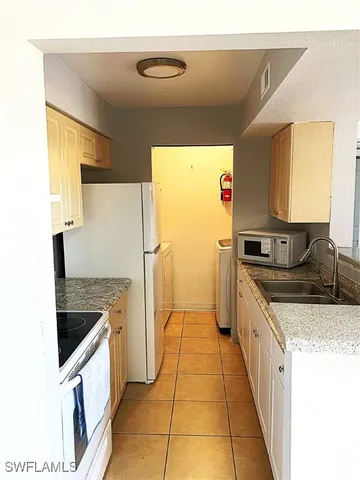 a kitchen with granite countertop a refrigerator and a stove
