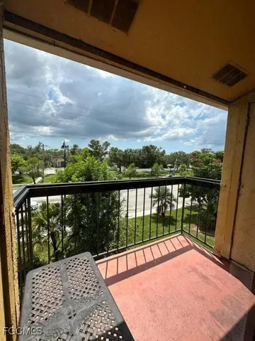 a view of a balcony with a floor to ceiling window next to a yard