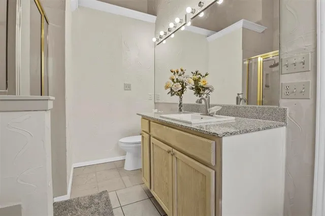 a bathroom with a granite countertop sink a toilet and a mirror