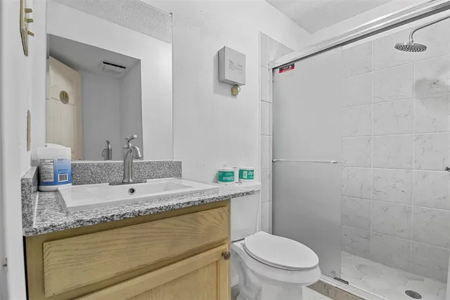 a bathroom with a granite countertop sink toilet and shower