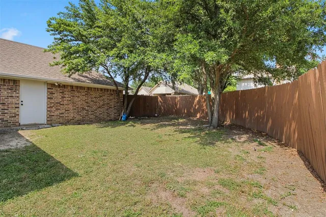 a view of a yard with wooden fence
