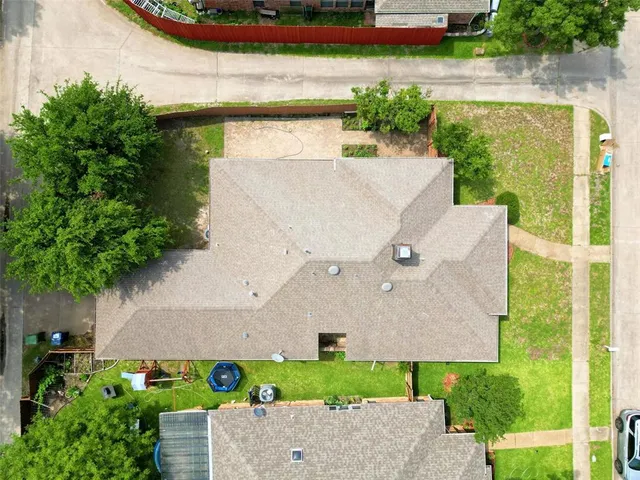 an aerial view of a house with a yard and pool