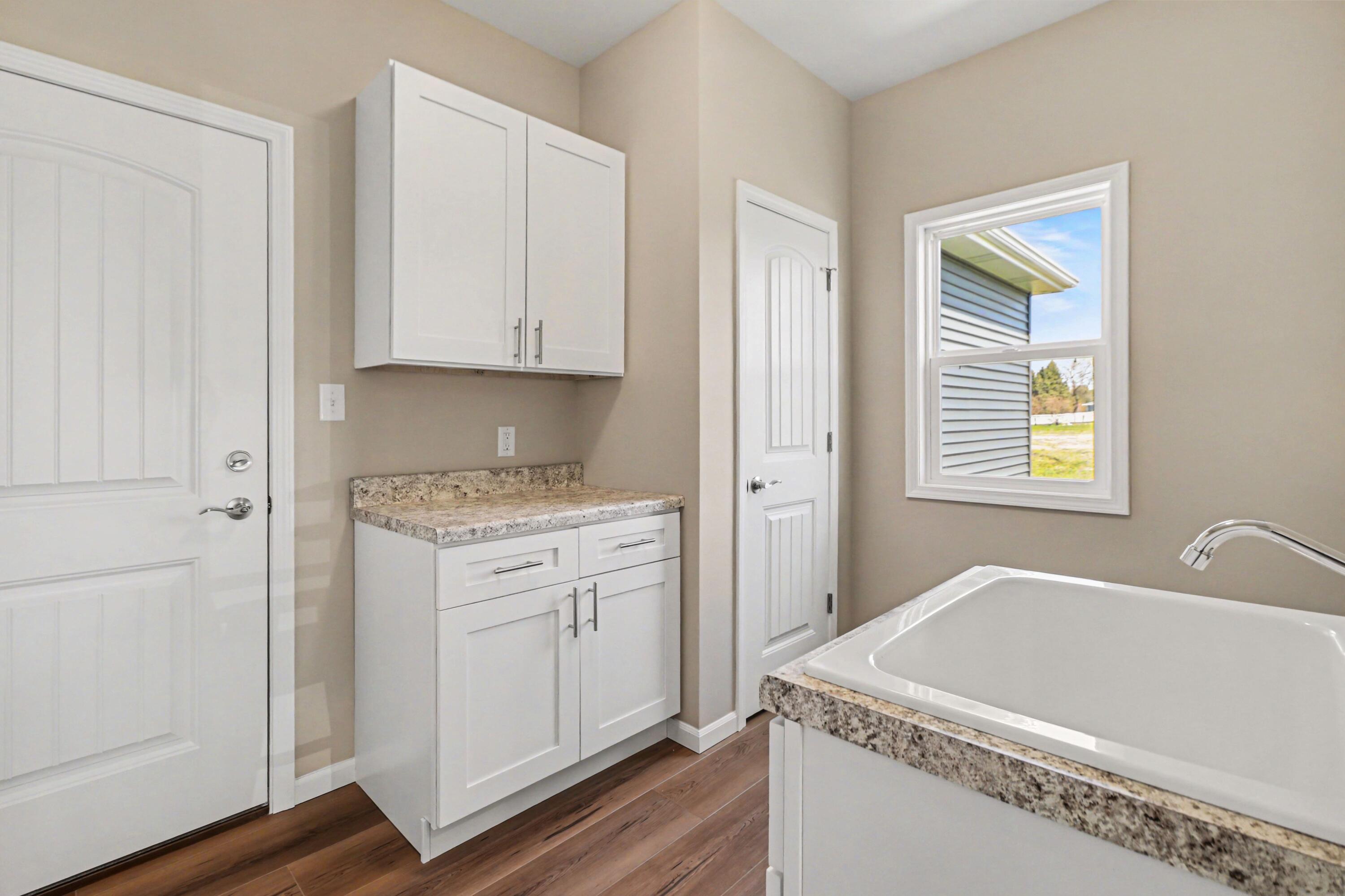 6071 Robbins Road Portage, IN 46368 - Photo 11 of 14 a bathroom with a granite countertop sink a mirror and a bathtub