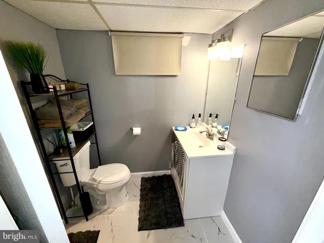 a bathroom with a sink a toilet a mirror and shower