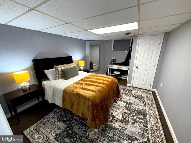 a bedroom with a bed and a flat tv screen on a table