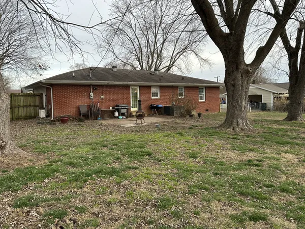 a front view of a house with yard and trees