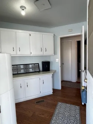 a kitchen with granite countertop white cabinets and stainless steel appliances