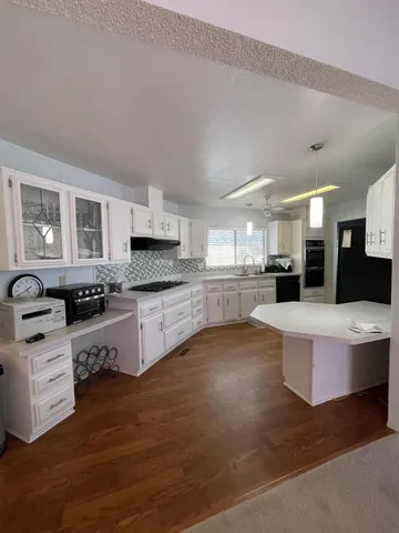 a large kitchen with a large counter top stainless steel appliances and cabinets