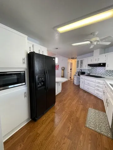 a large kitchen with stainless steel appliances kitchen island granite countertop a refrigerator and a stove top oven