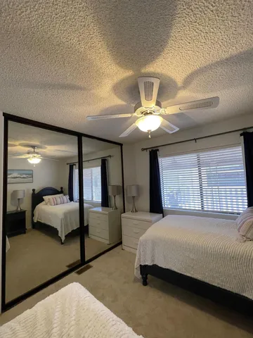 a spacious bedroom with a large bed and a chandelier