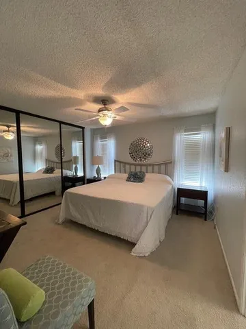 a spacious bedroom with a bed and large mirror