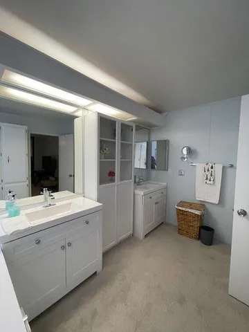 a bathroom with a sink and mirror with toilet