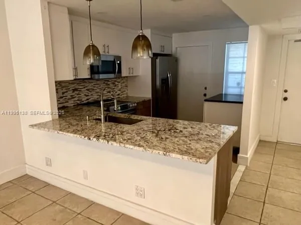 a kitchen with stainless steel appliances kitchen island granite countertop a sink and cabinets