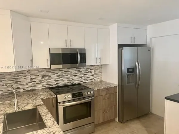 a kitchen with granite countertop cabinets and steel stainless steel appliances