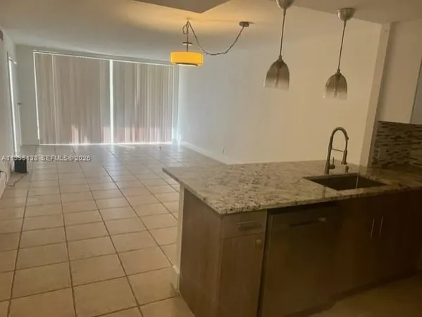 a kitchen with a sink a counter space and a view of a bathroom