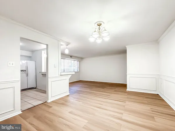 a view of a room with wooden floor and kitchen view