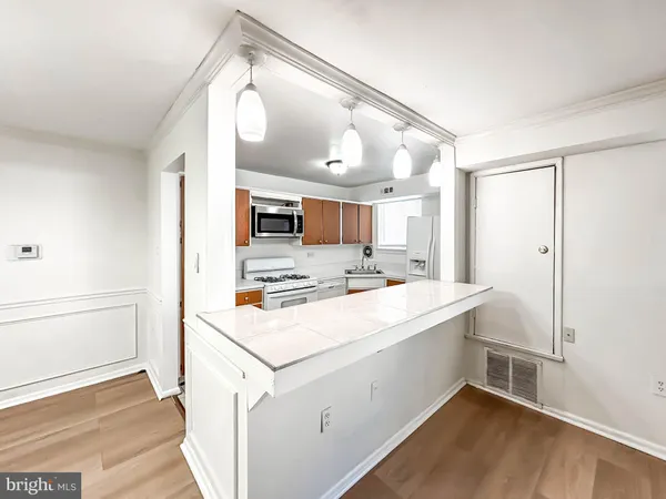 a view of a kitchen with a sink and wooden floor