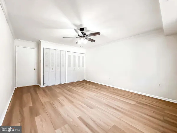 a view of a room with a ceiling fan and wooden floor