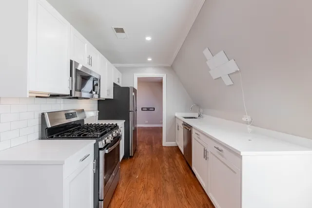 a kitchen with stainless steel appliances a sink stove and cabinets