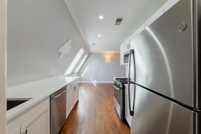a view of a kitchen with a sink and refrigerator
