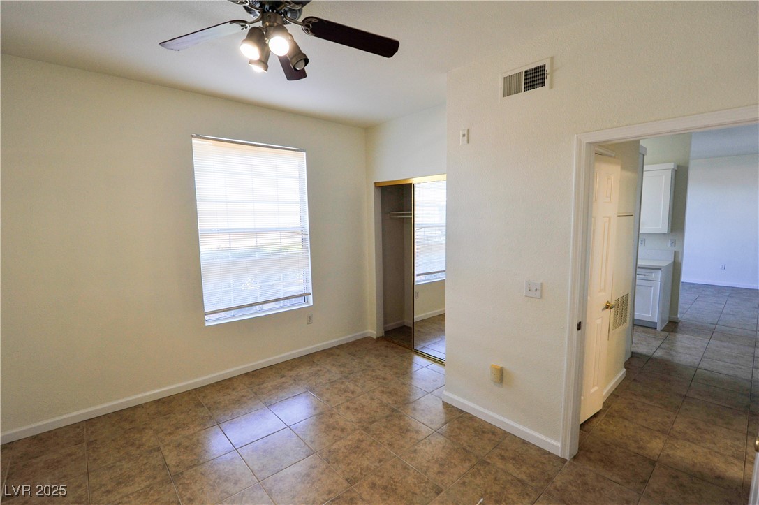 231 West Horizon Ridge Parkway, Unit 1113 Henderson, NV 89012 - Photo 14 of 23 Unfurnished bedroom with a closet, dark tile patterned floors, and ceiling fan