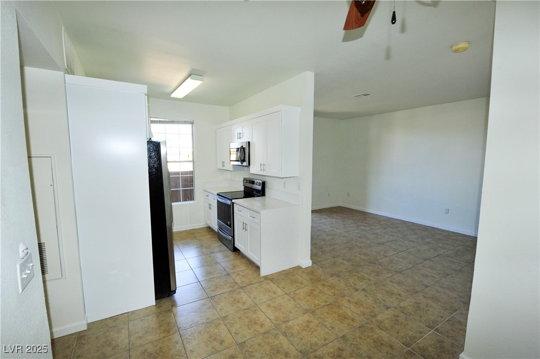 231 West Horizon Ridge Parkway, Unit 1113 Henderson, NV 89012 - Photo 7 of 23 Kitchen with stainless steel appliances, light countertops, white cabinets, a ceiling fan, and light tile patterned flooring