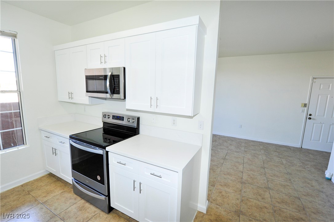 231 West Horizon Ridge Parkway, Unit 1113 Henderson, NV 89012 - Photo 8 of 23 Kitchen featuring stainless steel appliances, white cabinets, and light tile patterned floors