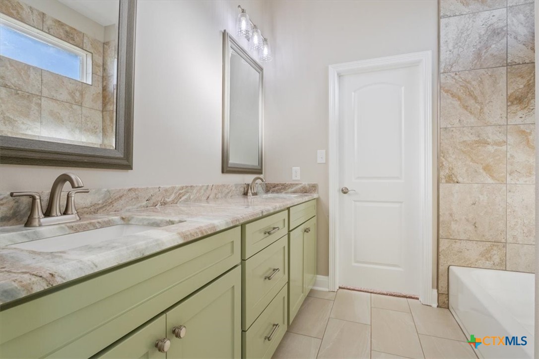 14308 Fm 2904 Temple, TX 76501 - Photo 31 of 45 a bathroom with a granite countertop sink and a mirror