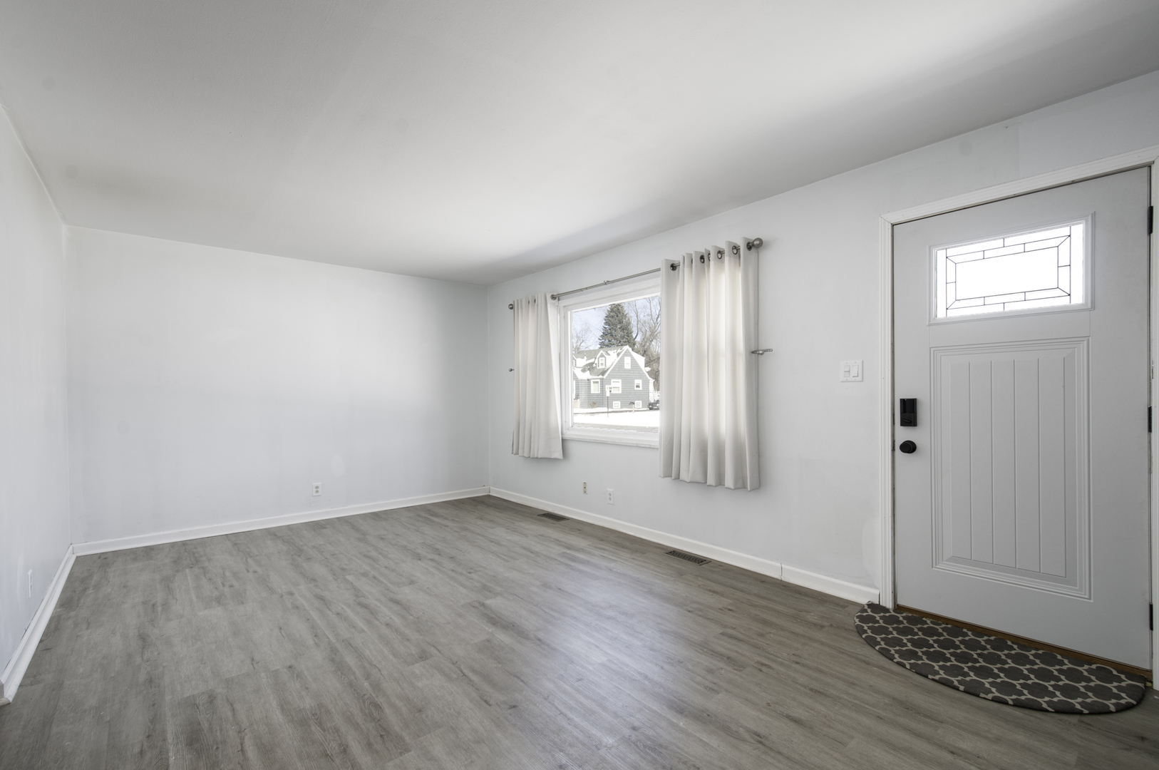 14526 Ridgeway Avenue Midlothian, IL 60445 - Photo 3 of 17 an empty room with wooden floor and windows