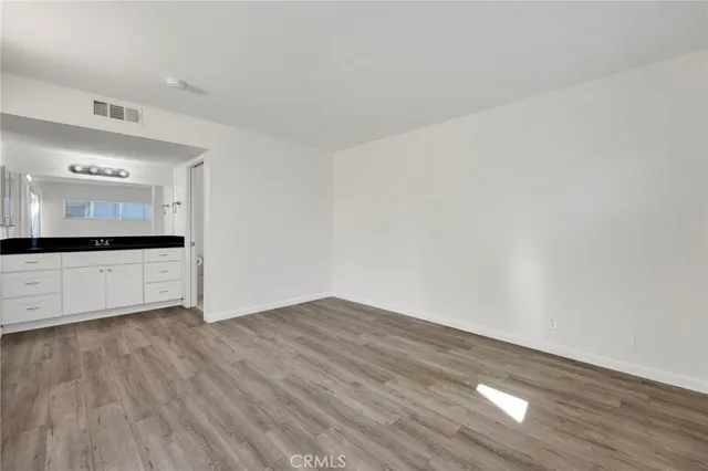 a view of a kitchen with wooden floor and a sink
