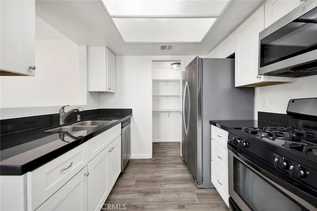 a kitchen with stainless steel appliances a sink stove and refrigerator