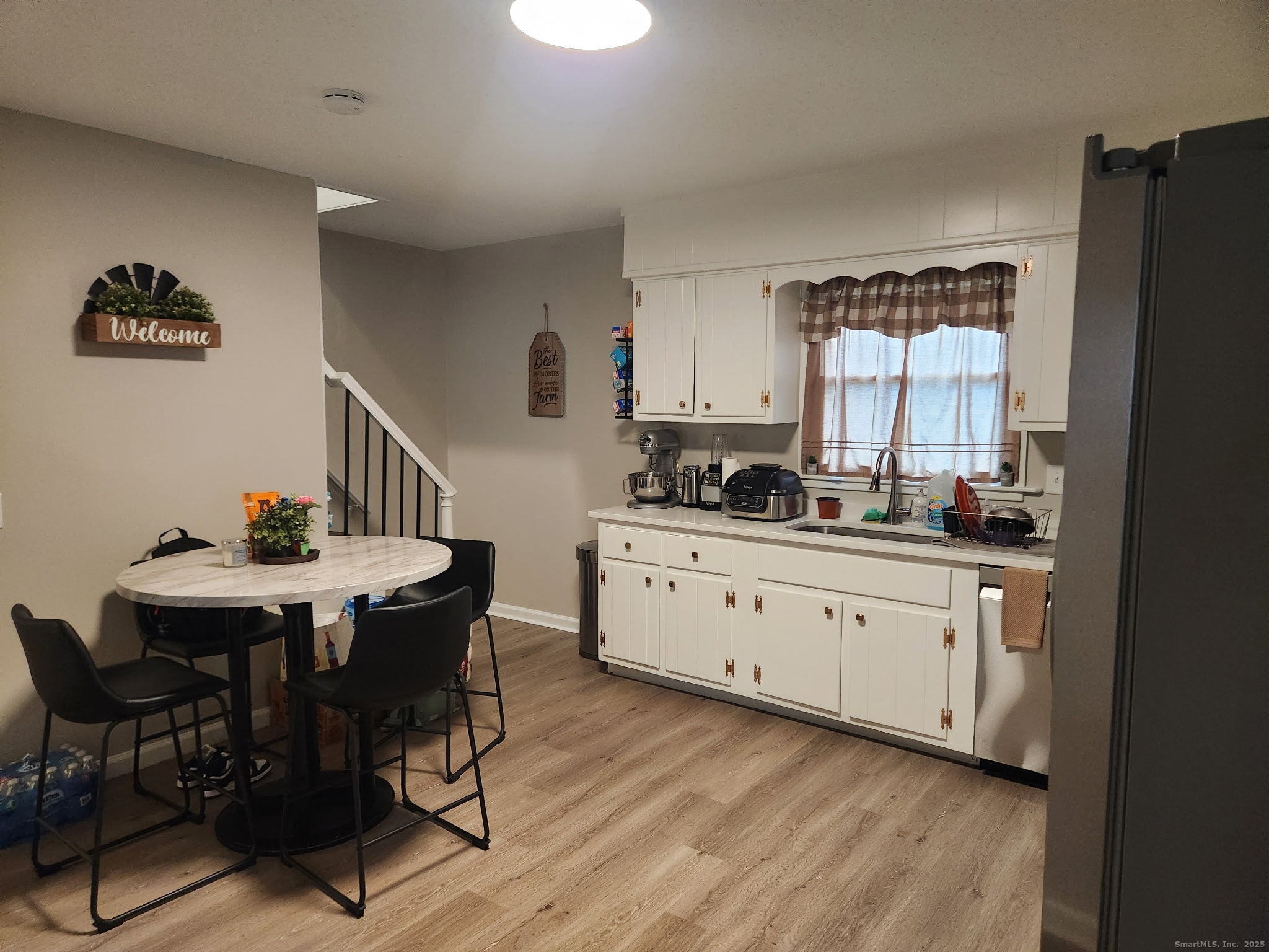 515 Liberty Street, Unit 515 Meriden, CT 06450 - Photo 8 of 11 a kitchen with stainless steel appliances a table chairs and a refrigerator