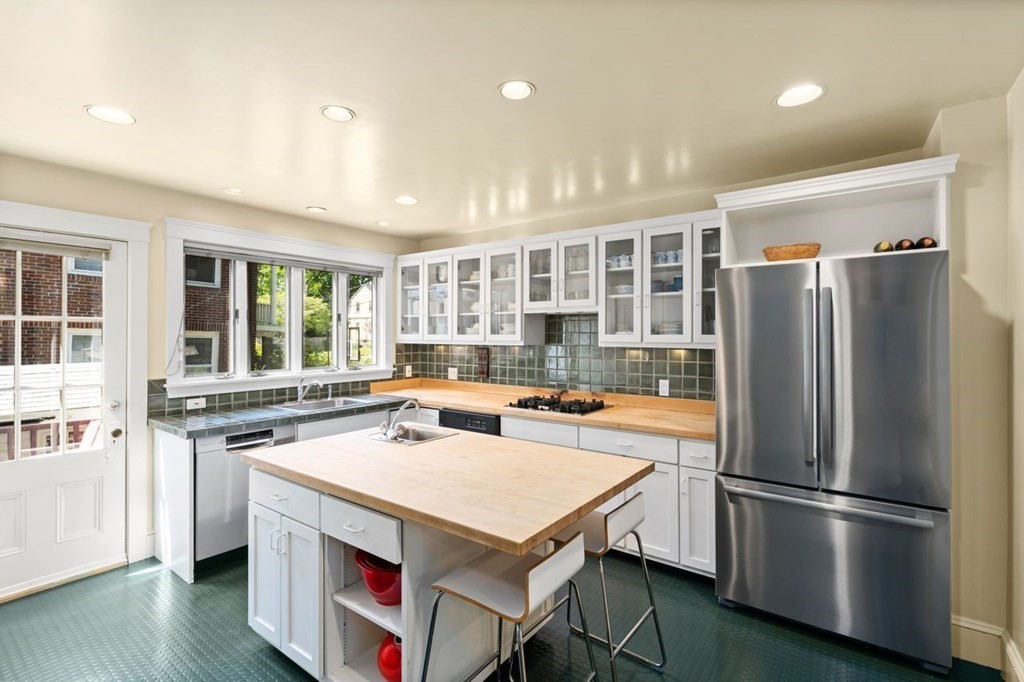 18 Stoneleigh Road, Unit 18 Newton, MA 02465 - Photo 1 of 26 a kitchen with a refrigerator a stove a sink dishwasher and a dining table with wooden floor