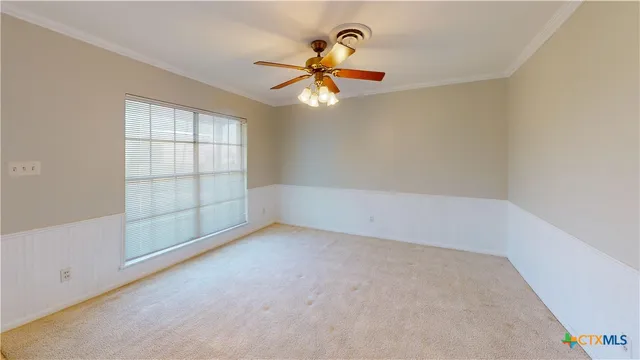 an empty room with windows and fan