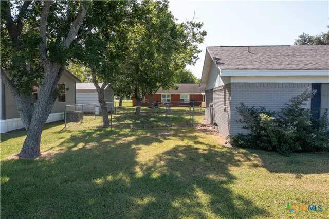 a view of a house with a yard garage and sitting area