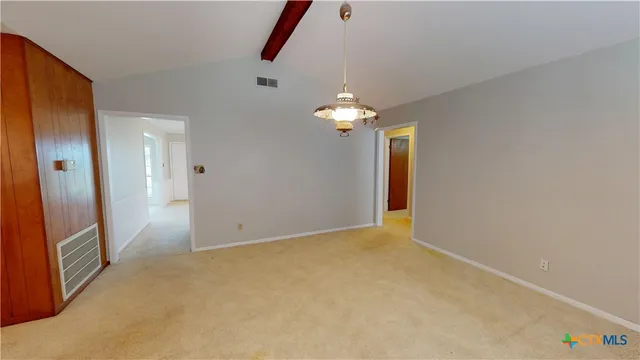 a view of an empty room with a chandelier