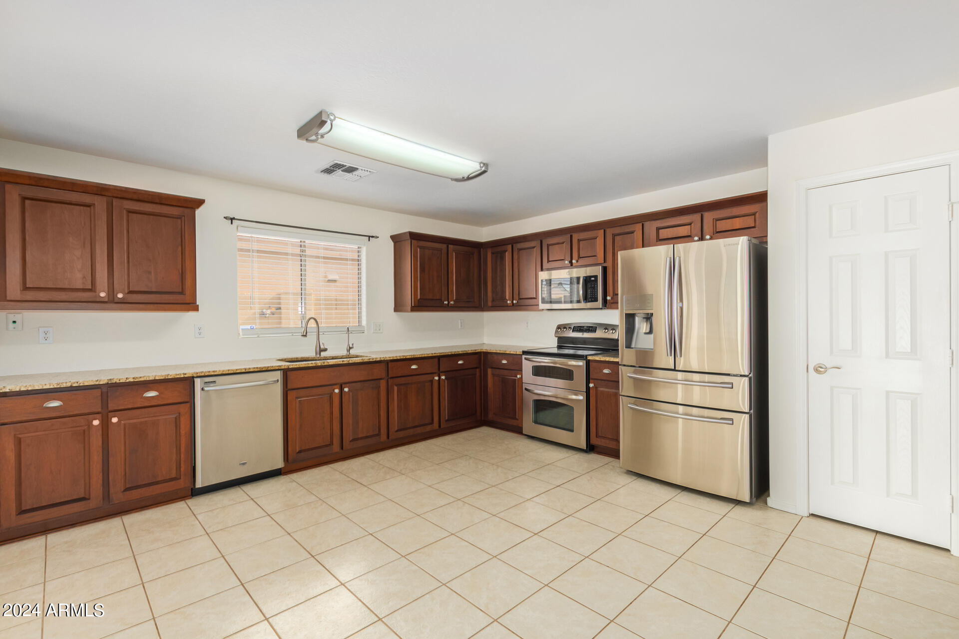 2328 West Carson Road Phoenix, AZ 85041 - Photo 14 of 42 a kitchen with stainless steel appliances granite countertop a refrigerator sink and cabinets
