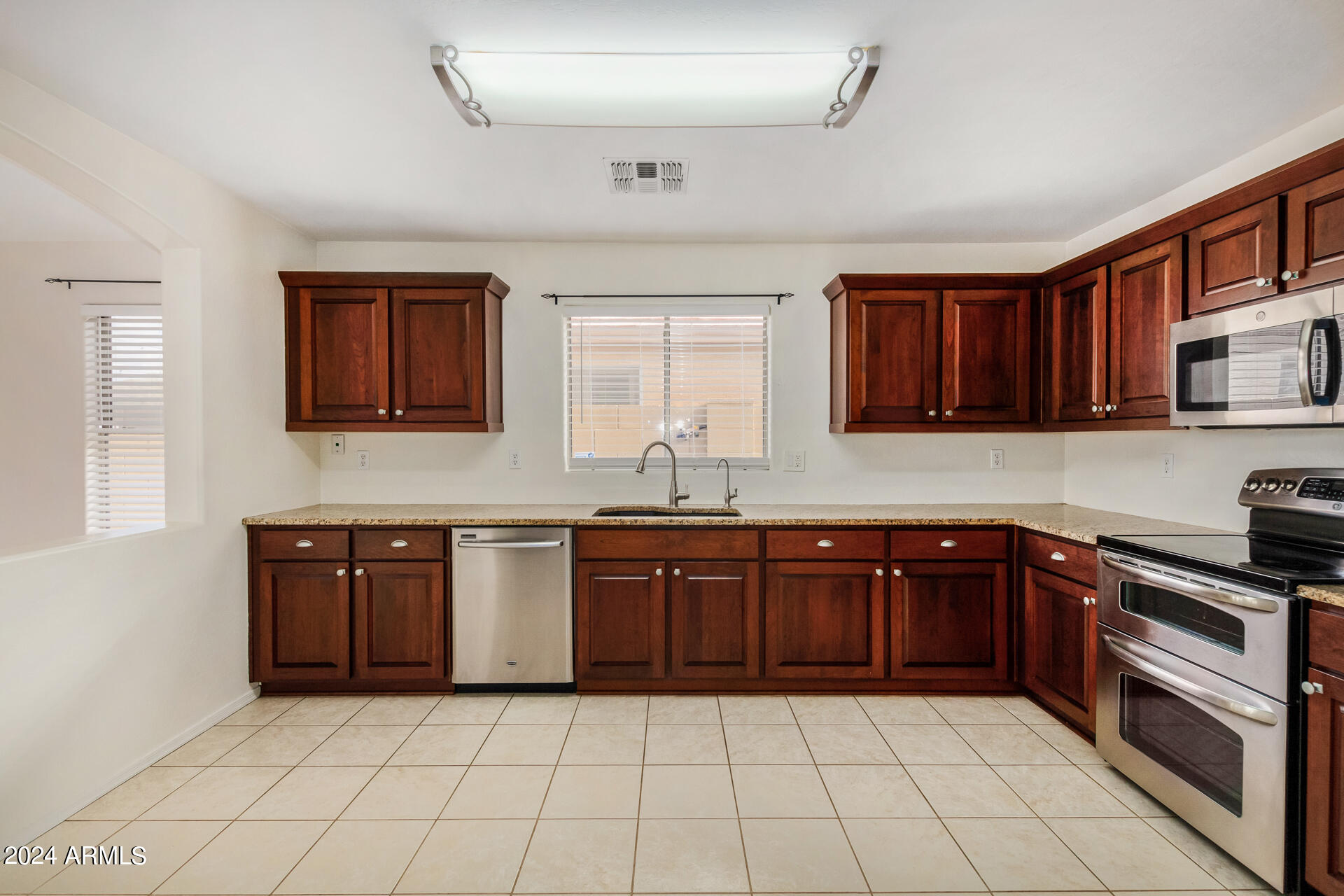 2328 West Carson Road Phoenix, AZ 85041 - Photo 17 of 42 a kitchen with stainless steel appliances granite countertop a sink and cabinets
