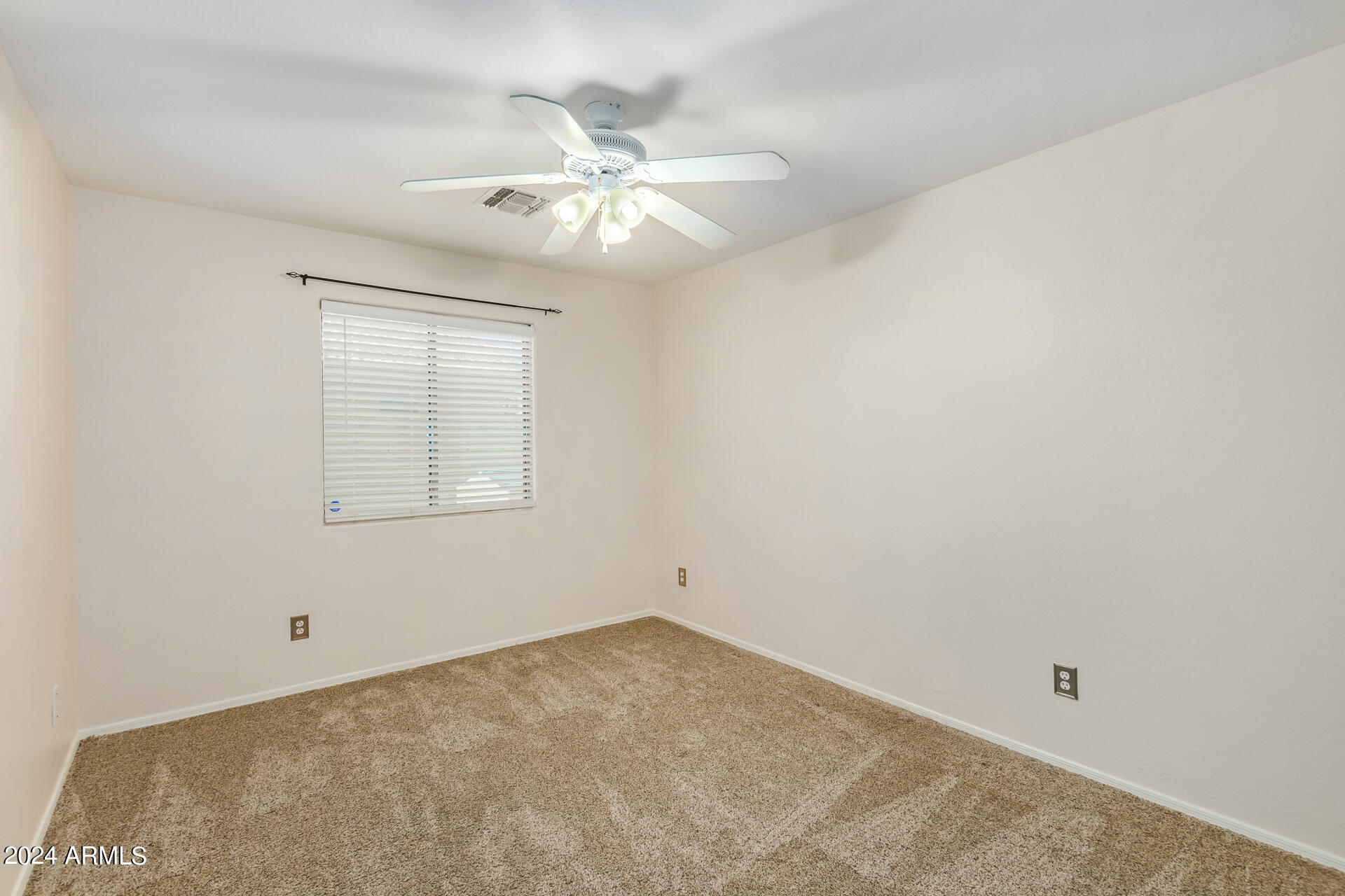 2328 West Carson Road Phoenix, AZ 85041 - Photo 29 of 42 an empty room with a chandelier fan and windows