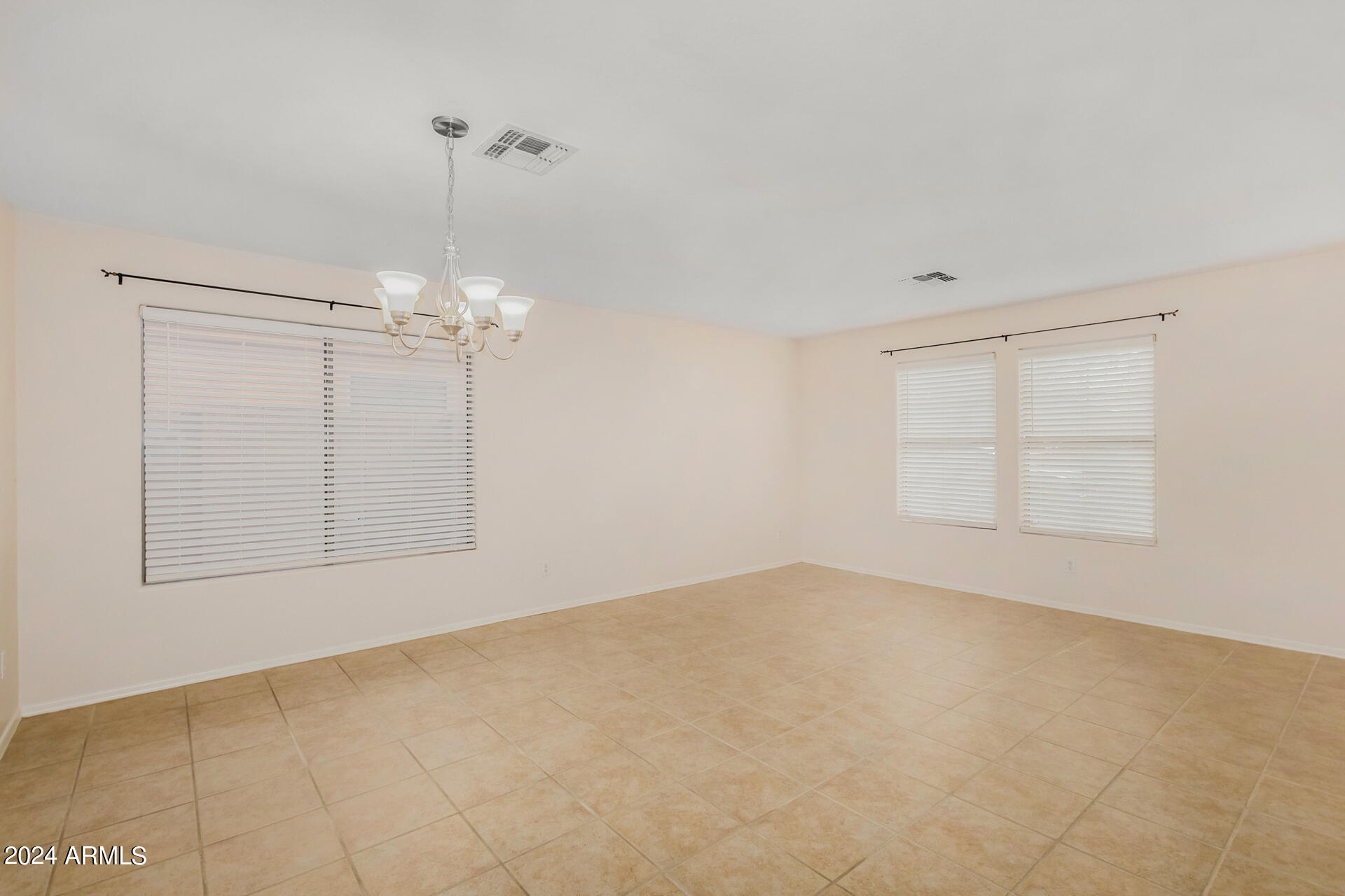 2328 West Carson Road Phoenix, AZ 85041 - Photo 5 of 42 an empty room with chandelier fan and windows