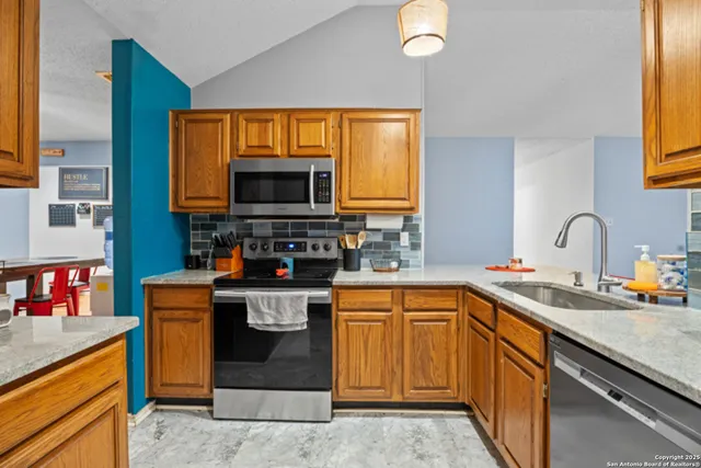 a kitchen with stainless steel appliances granite countertop a sink stove and microwave