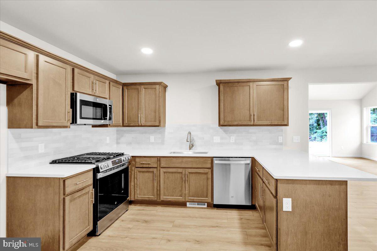 2450 Jefferson Avenue Reading, PA 19609 - Photo 9 of 33 a kitchen with stainless steel appliances granite countertop a stove a sink dishwasher and a microwave oven with wooden cabinets