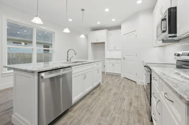 a kitchen with a sink stove and cabinets
